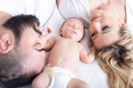 young family with newborn at home smiling
